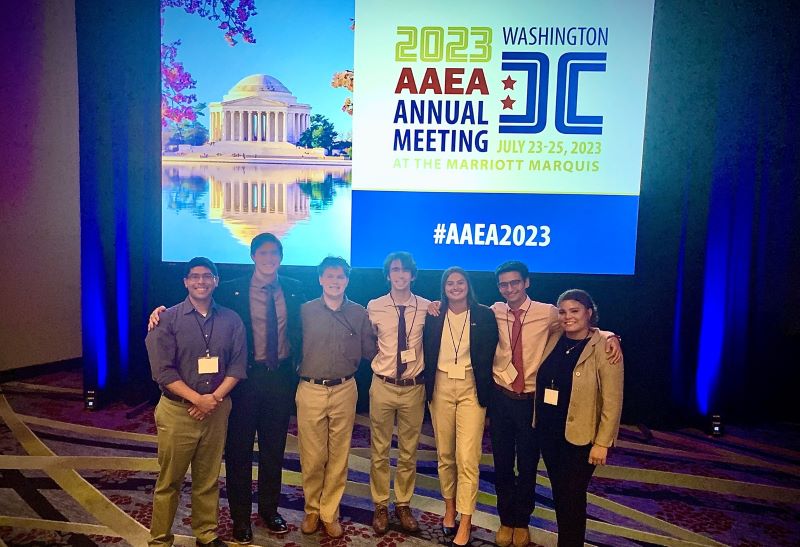 Seven LSU College of Ag students in front of the convention banner 