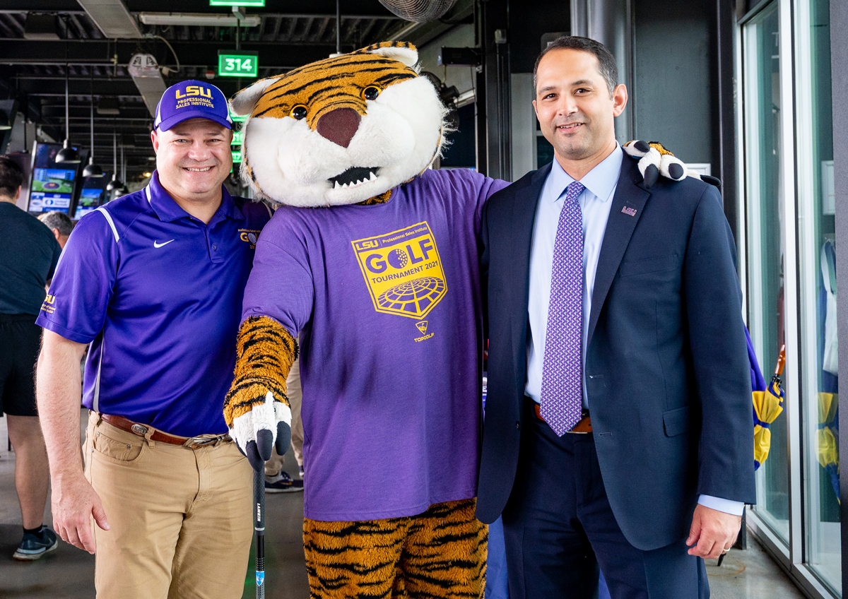 Greg Accardo, Mike the Tiger, and Dean Llorens stand close and smile at TopGolf