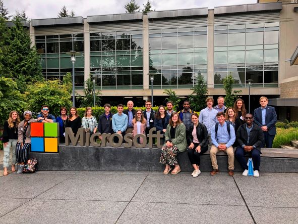 Group of students next to Microsoft headquarters sign. 