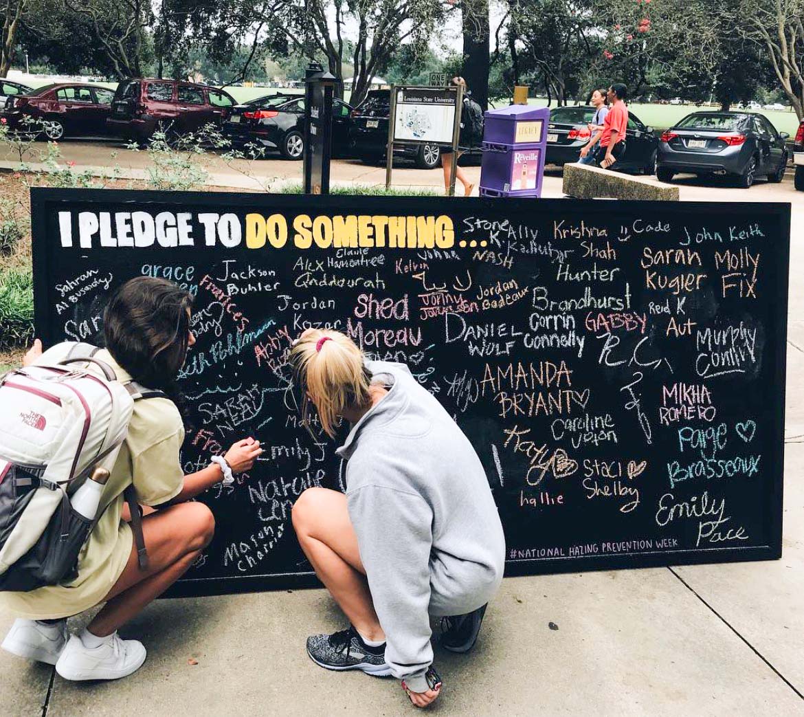 students writing on Hazing Prevention chalk wall